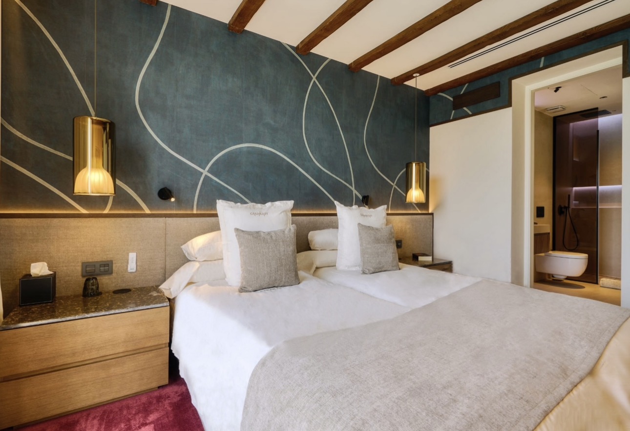 Suite de CasaKary con mural verde y lámparas de latón