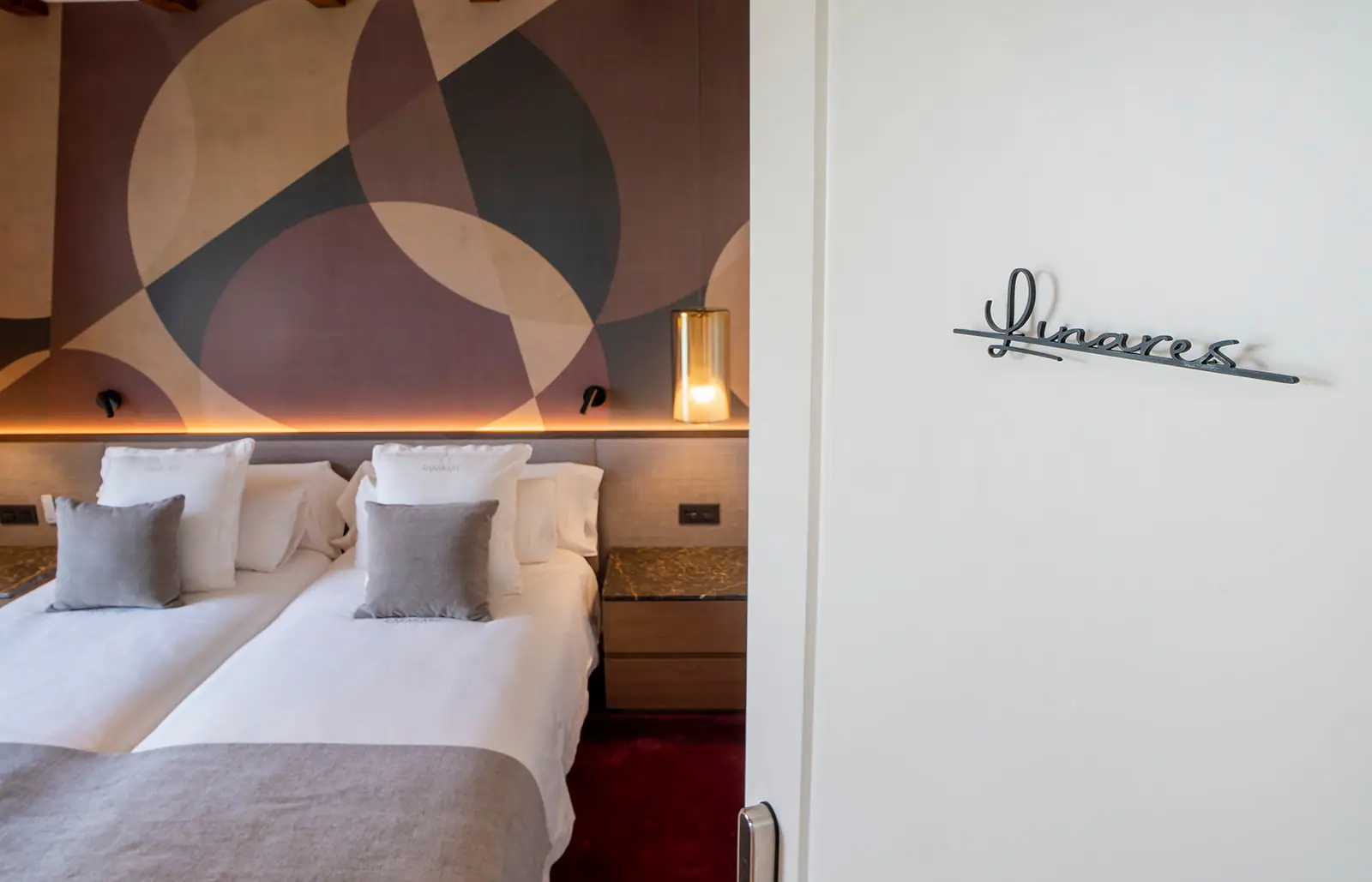 Suite Linares con mural geométrico y su nombre en la puerta